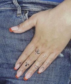 a woman's hand with tattoos on her fingers