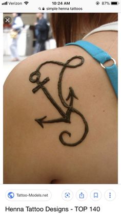 the back of a woman's shoulder with an anchor tattoo on it