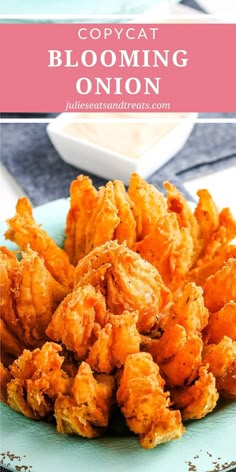 a blue plate topped with fried food next to a bowl of dipping sauce