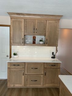 a kitchen with wooden cabinets and white counter tops