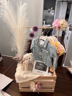 a teddy bear sitting on top of a wooden crate filled with clothes and other items