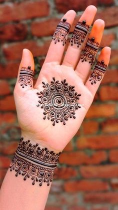 henna tattoo on the palm of a woman's hand, with intricate designs