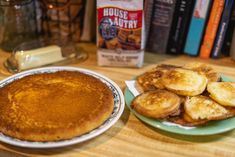 a table topped with two plates filled with pancakes next to a stack of cookies and milk