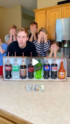 a group of people standing in front of a counter with bottles and candles on it