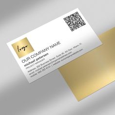 a business card with gold foil on the front and back, sitting on top of a silver surface