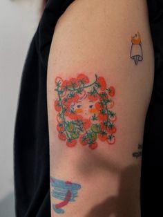 a woman's arm with tattoos on it and flowers in the middle of her arm