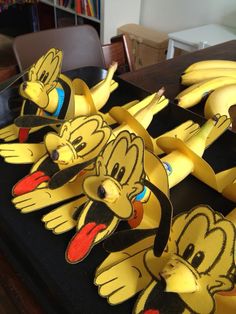 some bananas that have been cut out to look like cartoon characters on them, sitting on a table