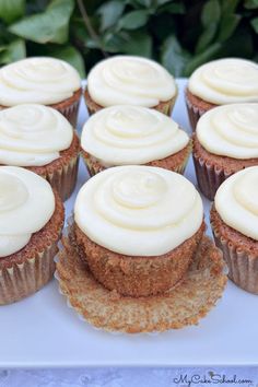 cupcakes with white frosting sitting on a plate