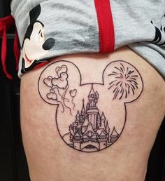 a person with a mickey mouse tattoo on their thigh and some fireworks in the air