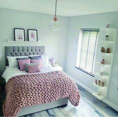 a bedroom with white walls and pink bedding