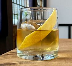 a glass filled with liquid and a lemon wedge