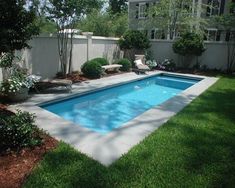 a backyard with a swimming pool surrounded by grass