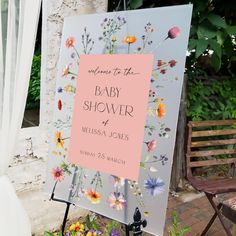 a baby shower sign with flowers on it