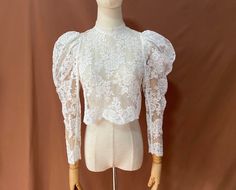 a mannequin wearing a white lace top