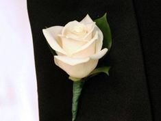 a white rose is placed on the lapel of a black suit