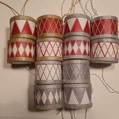 several different colored and patterned candles are hanging on a wall