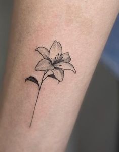 a single flower tattoo on the ankle is shown in black and grey ink, with an outline