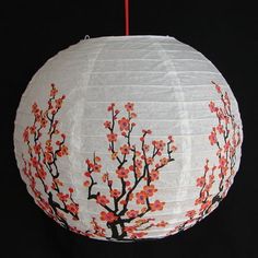 a white paper lantern with red flowers on it