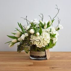 a vase filled with white flowers on top of a wooden table