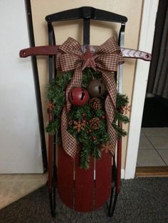 a wooden sled with a christmas wreath on it and a reindeer head hanging from the front