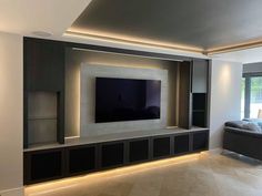 modern living room with built - in entertainment center and large flat screen tv mounted on the wall