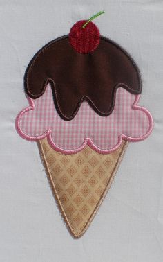 an ice cream cone with a cherry on top and pink gingham checkered fabric