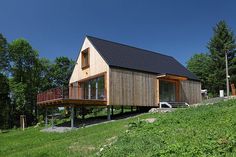 a small wooden house sitting on top of a lush green hillside