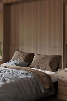 a large bed sitting next to a window with wooden headboard and pillows on top of it