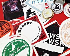 many different stickers and badges on a red table with a black dog in the middle