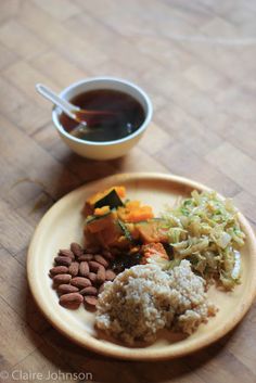 a wooden table topped with a plate of food and a cup of tea