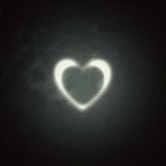 a heart shaped object in the dark with white light shining on it's side