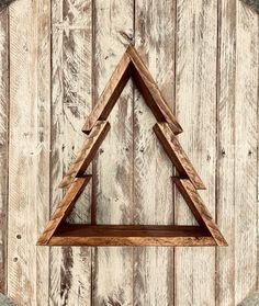 a wooden shelf sitting on top of a wooden wall with a triangle shaped shelf in the middle