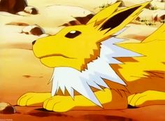 a yellow pokemon sitting on top of a sandy ground