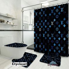 a bathroom with black and blue decor on the shower curtain, toilet and rugs