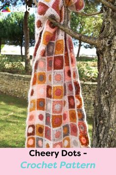 a crocheted blanket hanging from a tree with text overlay that reads, cherry dots - crochet pattern