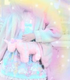 a girl holding a pink poodle toy in her hand while wearing a pastel outfit