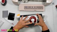 a woman is using a sewing machine to sew something on the counter top with her hands