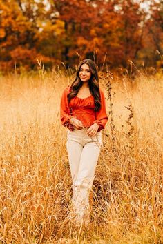 a woman standing in the middle of tall grass