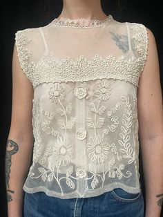 Item Details. From France C1930s this pretty and romantic lace camisole top which is covered in patterned of applied silk braid which has been stitched in decorative patterns (soutache) This lovely too would look great with jeans as shown in our photos or with a skirt or smart trousers for a more dressy look. The blouse fastens down the centre back with tiny hidden poppers. Measurements: All taken whilst garment is laying flat. Our model Amie is a UK size 8. Across front 43cm (17 inches) Length from shoulder to hem 49cm (19.5 inches) Condition. In excellent wearable condition.  All of our specially chosen pieces are antique and have the idiosyncrasies of antique and loved garment so small marks, stains and signs of wear are to be expected and are an inherent part of their charm and history Fitted Camisole With Crochet Lace, Victorian Fitted Tops For Summer, Fitted Victorian Summer Tops, Fitted Victorian Tops For Summer, Crochet Lace Camisole Top, Fitted Lace Crochet Camisole Top, Fitted Beige Tops With Delicate Lace, Vintage Fitted Sleeveless Camisole, Fitted Vintage Camisole For Spring