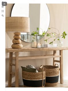 a table with two baskets on it next to a mirror