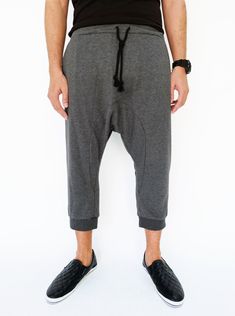 "🚚..ALL ORDERS ARE SHIPPED VIA DHL EXPRESS MAIL Harem-style sweatpants with a cropped profile. Made of stretch cotton-blend jersey, these cropped pants are comfortable to wear and easy to move in. * Pull-on style * Drop-crotch style * Elastic waistband with black drawstring * Side slant pockets * Ribbed ankle cuffs * Cropped length Measurements approximately: Waist: 27\" (68.5 cm) stretching to 48\" (122 cm) Hips: 50\" (127 cm) Outseam: 31\" (79 cm) In Front Rise: 17 1/2\" (44 cm) In Back Rise: Sporty Relaxed Fit Bottoms With Belt Loops, Gray Relaxed Fit Bottoms With Belt Loops, Casual Breeches With Pockets And Tapered Leg, Drop Crotch Bottoms With Side Pockets And Relaxed Fit, Relaxed Fit Drop Crotch Bottoms For Streetwear, Baggy Bottoms With Pockets, Style Sweatpants, Unisex Pants, Ankle Cuffs