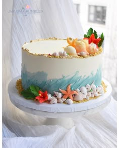 there is a cake with shells and flowers on the top it's frosting