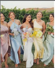 a group of women standing next to each other holding bouquets in their hands and laughing