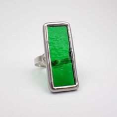 Large, transparent, rectangular bright green textured stained glass ring edged in silver. The sterling silver wire band is approximately size 10. This is a one of a kind ring.  Approximate Ring Size: US 10 / UK T 1/2 Center Glass Size:  1 3/8" x 9/16" Each item by Faerie Glass is 100% uniquely hand-crafted with quality materials that are lead-free. NOTE - All photographs are taken in effort to best represent the actual product. Color of actual jewelry may vary slightly from photographs. Stained Glass Ring, Green Zone, Green Texture, Glass Ring, Glass Rings, Bright Green, Silver Wire, Rings Statement, Statement Rings