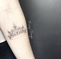 a small crown tattoo on the arm