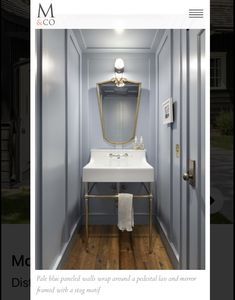 a bathroom with a sink and mirror in the corner next to a light on the wall