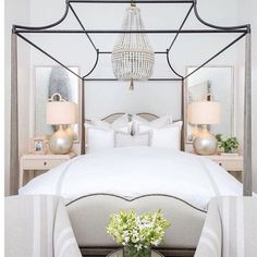 a bedroom with a white bed and chandelier over it's headboard