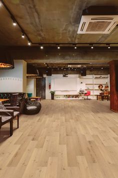 an empty room with wooden floors and chairs