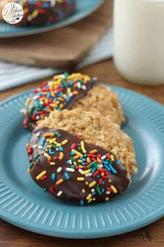 two donuts with chocolate frosting and sprinkles on a blue plate