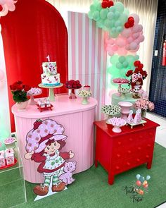 there is a pink and red table with balloons on it at a birthday party or baby shower